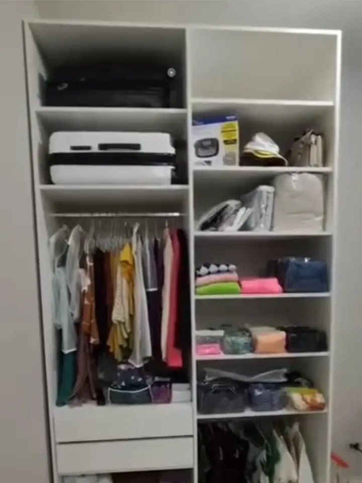 Guarda-roupa com malas no alto, roupas penduradas e nichos organizados
