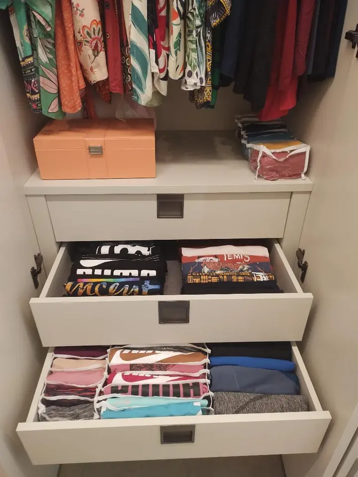 Gavetas abertas com camisetas e roupas dobradas